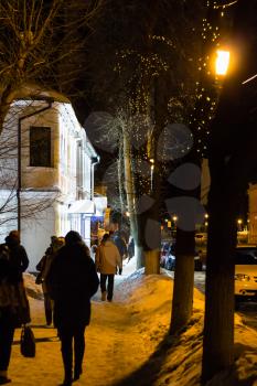 people on street in Suzdal town in winter evening in Vladimir oblast of Russia