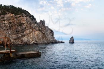travel to Crimea - view of pier near Swallow Nest castle in Gaspra District and Parus (Sail) rock on Crimean Southern Coast of Black Sea in evening