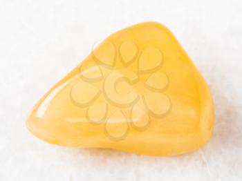 macro shooting of natural mineral rock specimen - tumbled yellow Aventurine gem stone on white marble background from India