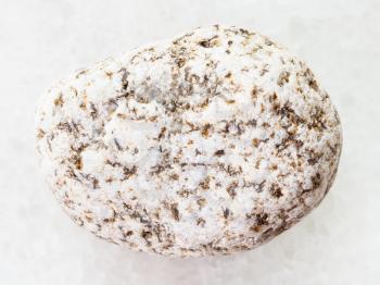 macro shooting of natural mineral rock specimen - white Granite stone on white marble background