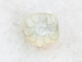 macro shooting of natural mineral rock specimen - polished translucent moonstone gemstone on white marble background