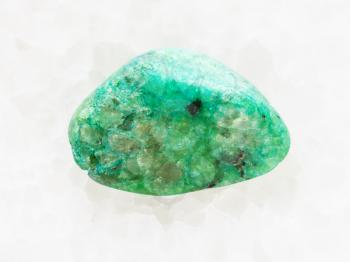 macro shooting of natural mineral rock specimen - pebble of green Agate gemstone on white marble background from Mexico