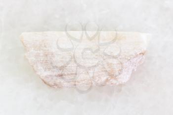macro shooting of natural mineral rock specimen - rough Talc stone on white marble background