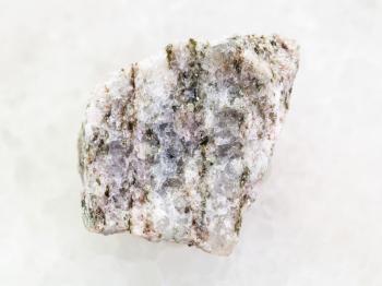 macro shooting of natural mineral rock specimen - raw Apatite ( ore of phosphorus) stone on white marble background