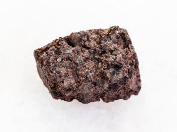 macro shooting of natural mineral rock specimen - rough Peat Turf stone on white marble background
