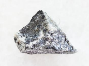 macro shooting of natural mineral rock specimen - raw stibnite (antimonite) ore on white marble background
