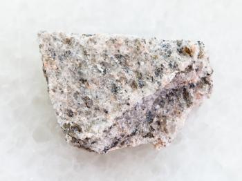 macro shooting of natural mineral rock specimen - rough Schist stone on white marble background
