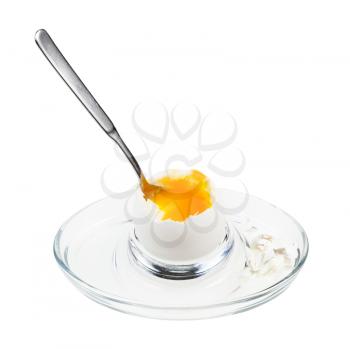 open soft-boiled white egg with spoon in glass egg cup isolated on white background