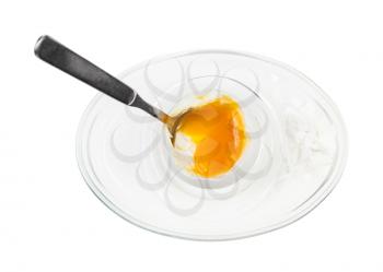 top view of open soft-boiled white egg with spoon in glass egg cup isolated on white background