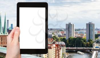 travel concept - tourist photographs Berlin city with Nikolaikirche and Muhlendammbrucke (Mill Dam Bridge) over Spree River in Germany in september on tablet with cut out screen for advertising logo