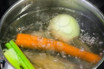 cooking soup - boiling meat broth in steel stewpan close up