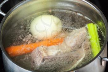 cooking soup - boiling beef broth in stew pan close up