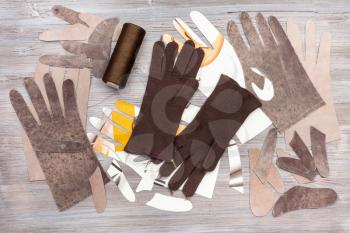 workshop on sewing gloves - top view of various items for gloves production on wooden background