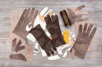 workshop on sewing gloves - top view of various details for gloves production on wooden background