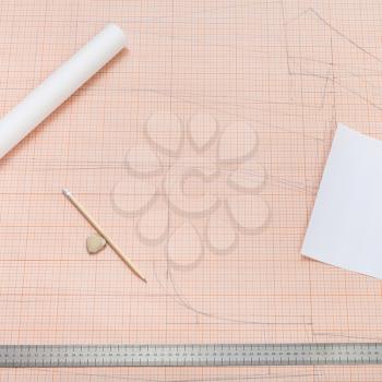 top view of drawing tools to make of clothing pattern on sheet of graph paper
