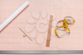 top view of tools for clothing pattern drawing on sheet of graph paper