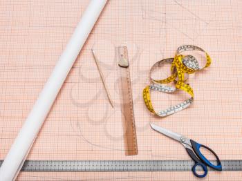 top view of items to draw a clothing pattern on sheet of graph paper