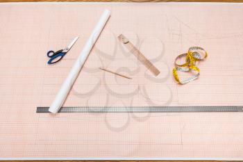 top view of tools to draw a clothing pattern on sheet of graph paper
