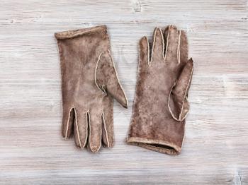 workshop on sewing gloves - top view of new hand-made sewn gloves on wooden background