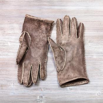 workshop on sewing gloves - top view of pair new hand-made gloves on wooden background