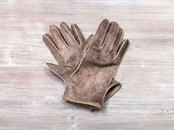 workshop on sewing gloves - top view of new hand-made leather gloves on wooden background