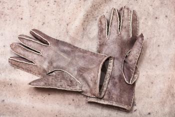 workshop on sewing gloves - top view of new hand-made sewn gloves on original natural leather background