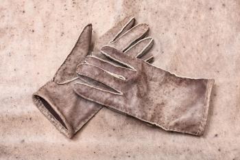 workshop on sewing gloves - top view of new hand-made stitched gloves on original natural leather background