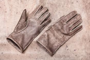 workshop on sewing gloves - top view of new hand-made gloves on original natural leather background