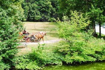 travel to France - horse carriage ride in park near castle Chateau de Sully-sur-Loire in Val de Loire region in sunny summer day