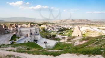 Travel to Turkey - modern and ancient rock-cut buildings in Uchisar town in Cappadocia in spring
