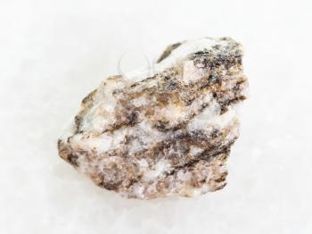 macro shooting of natural mineral rock specimen - rough Gneiss stone on white marble background
