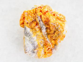 macro shooting of natural mineral rock specimen - yellow Orpiment crystals on white dolomite stone on white marble background from Kabardino-Balkarian Republic, Northern Caucasus Region, Russia