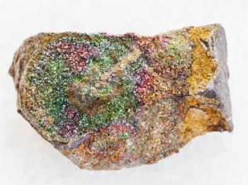 macro shooting of natural mineral rock specimen - rough rainbow pyrite stone on white marble background from Ulyanovsk region, Russia