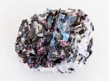 macro shooting of natural mineral rock specimen - raw Gneiss stone with biotite, kyanite, tourmaline crystals on white marble background from Hit-island of Upper Pulongskoye Lake, Karelia in Russia