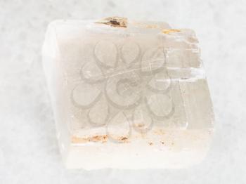macro shooting of natural mineral rock specimen - raw crystal of Iceland spar gemstone on white marble background from Krutoye, Evenkia in Krasnoyarsk region, Russia