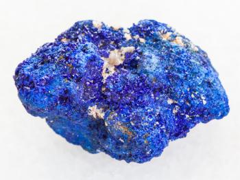 macro shooting of natural mineral rock specimen - raw crystalline Azurite stone on white marble background from Rubtsovskiy mine, Altai Mountains, Russia