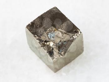 macro shooting of natural mineral rock specimen - raw pyrite crystal on white marble background from Spain