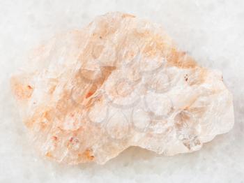 macro shooting of natural mineral rock specimen - raw belomorite stone (plagioclase moonstone) on white marble background from Karelia, Kola Peninsula in Russia