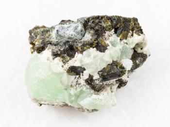 macro shooting of natural mineral stone specimen - Epidote crystals on prehnite gemstone on white marble background