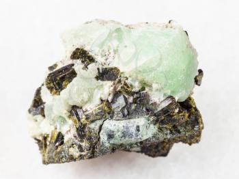 macro shooting of natural mineral stone specimen - Epidote crystals on prehnite stone on white marble background