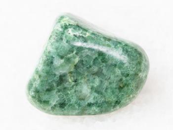 macro shooting of natural mineral rock specimen - polished green Jadeite gemstone on white marble background