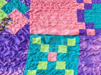 textile background - sewn square pieces of fabrics in stitched silk patchwork scarf