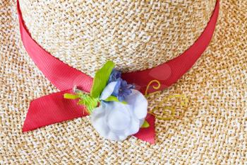 decoration of ladies' straw hat with red band and textile flower close up