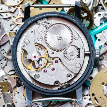 watchmaker workshop - mechanical clockwork on heap of clock spare parts