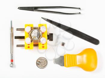 watchmaker workshop - top view of kit for replacing battery in watch on white background