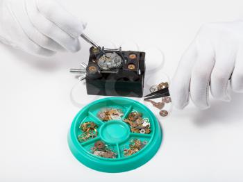 watchmaker workshop - above view of repairing old mechanical watch on white table