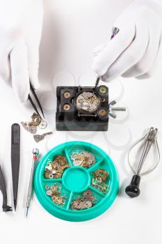 watchmaker workshop - top view of repairing old mechanical watch on white table