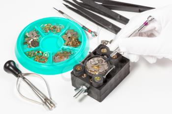 watchmaker workshop - repair of old mechanic wristwatch on white table