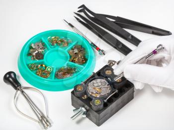 watchmaker workshop - repairing old mechanical wristwatch on white table