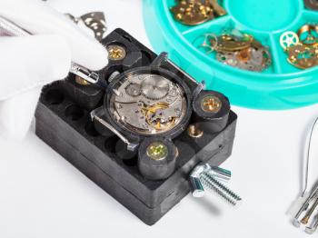 watchmaker workshop - repairing old mechanical wristwatch close up on white table